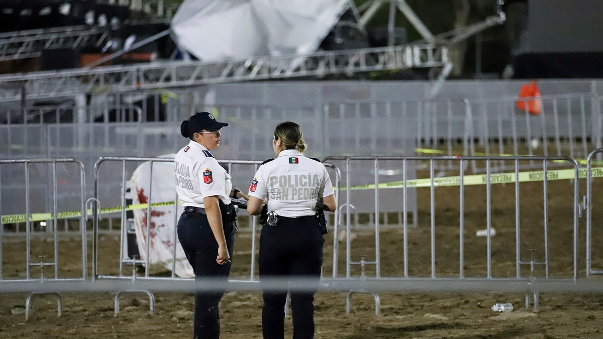 Mexican police standing near toppled stage