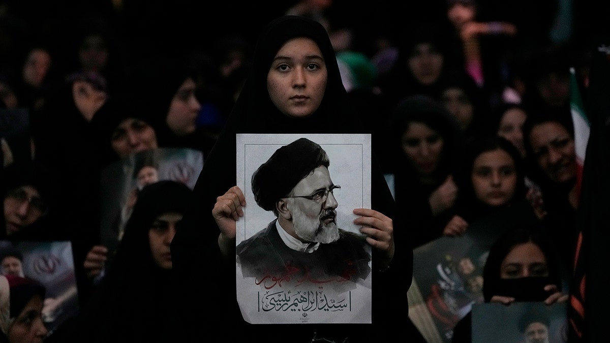 Mourner holds poster of President Raisi