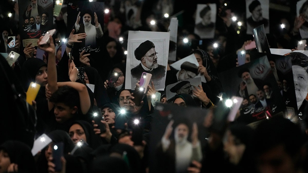 Mourners hold Raisi posters
