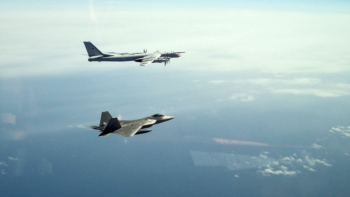 A North American Aerospace Defense Command F-22 Raptor flies next to a Russian Tu-95 bomber during an intercept in the Alaskan Air Defense Identification Zone on June 16, 2020.