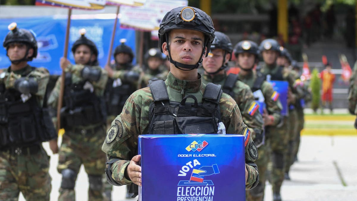 An army soldier holds a ballot box as he takes part in a military parade displaying electoral material to be used in the upcoming presidential elections at Fuerte Tiuna in Caracas on July 24, 2024.