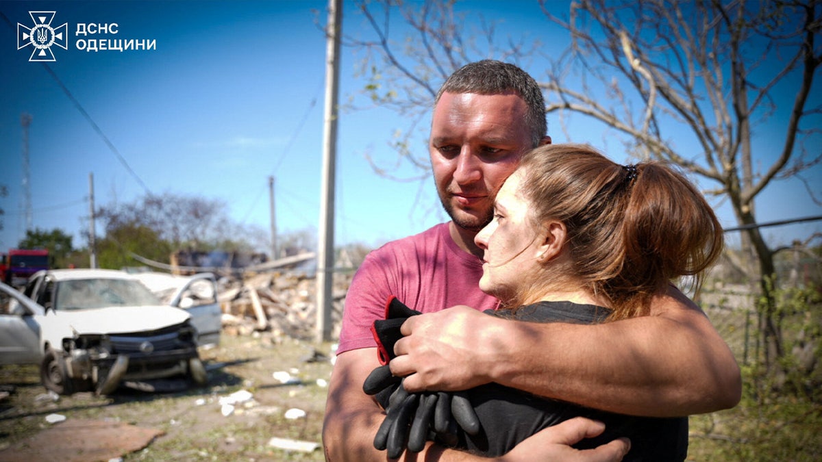 Local residents embrace each other at the site of a Russian missile strike, amid Russia's attack on Ukraine, in the Odesa region, on Aug. 26, 2024.