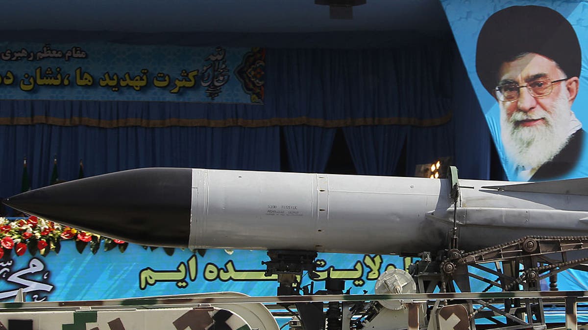 A military truck carries a missile past a portrait of Iran's Supreme Leader Ayatollah Ali Khamenei during an annual military parade.