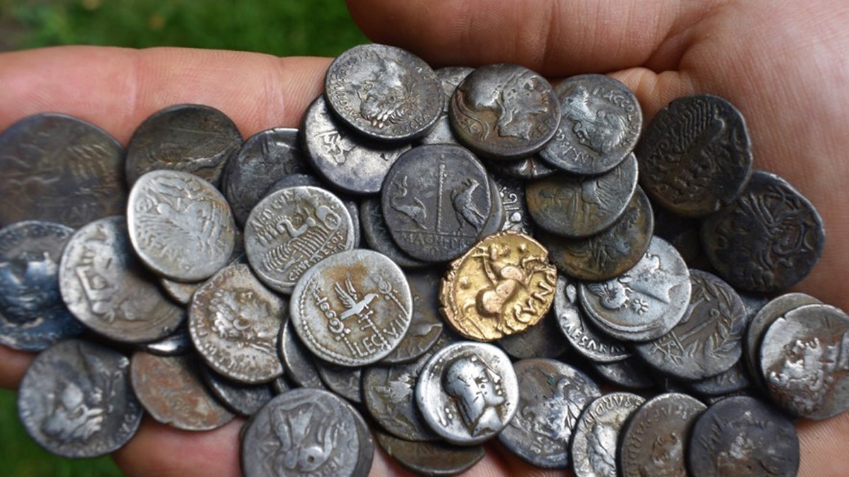 Ancient coins being held