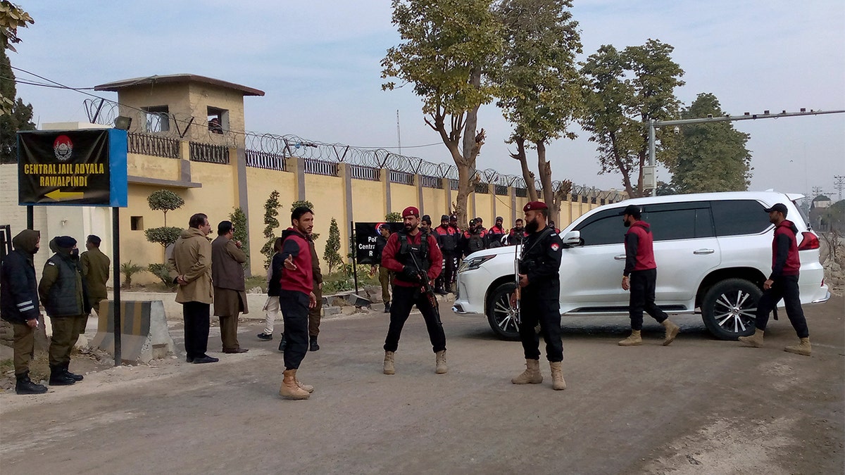 Security standing guard in front of a vehicle.