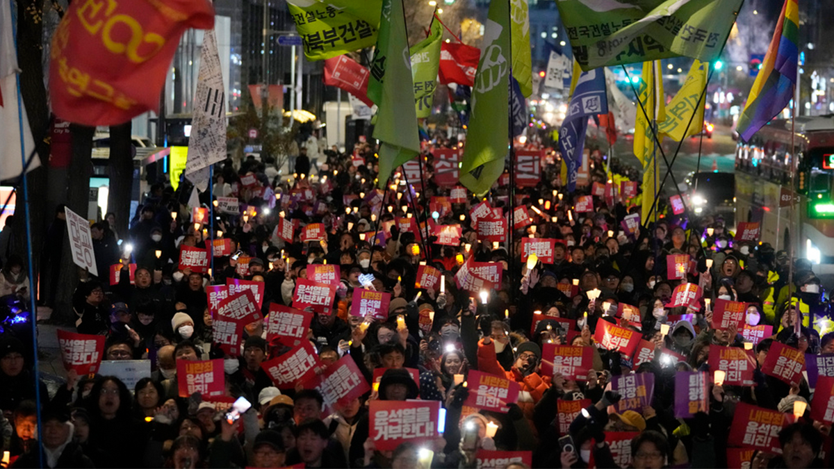 Protesters march to the presidential office after a candlelight vigil against South Korean President Yoon Suk Yeol in Seoul, South Korea, on Thursday, Dec. 5, 2024.