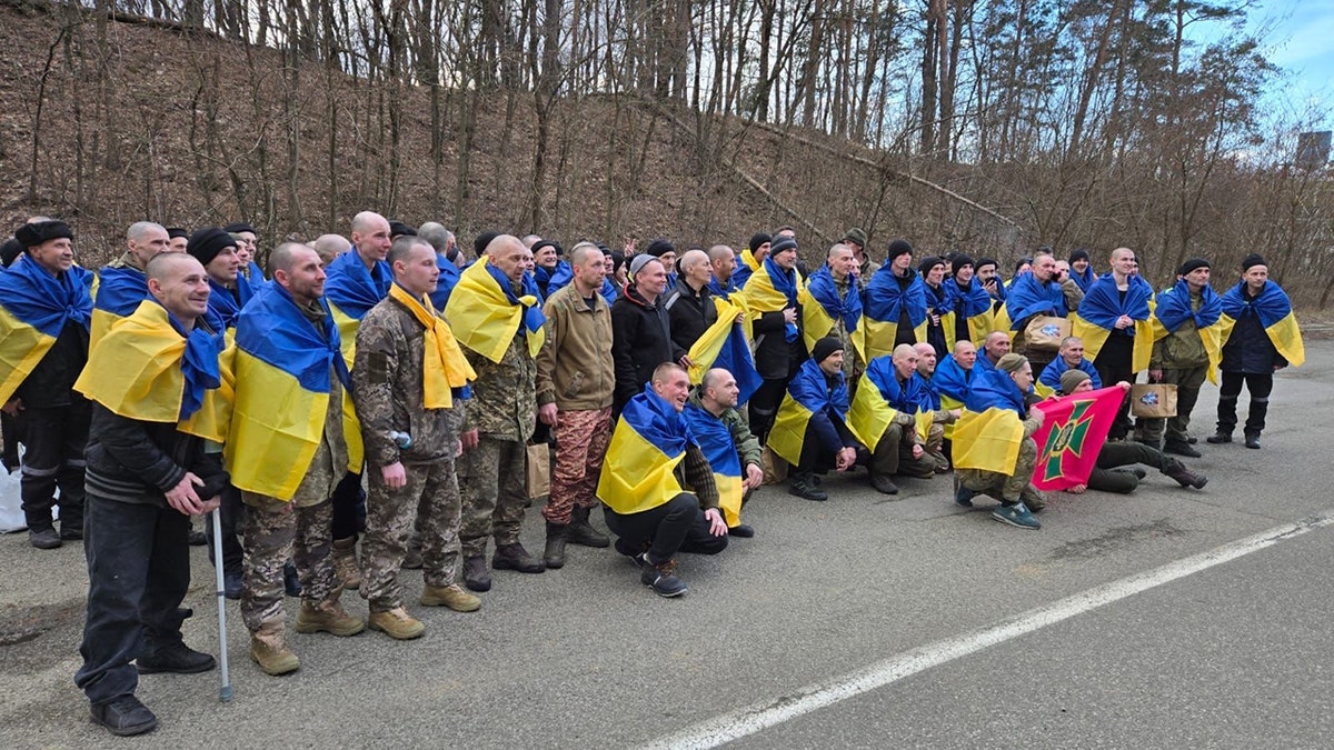 Ukrainian prisoners of war posing for a photo after returning to Ukraine