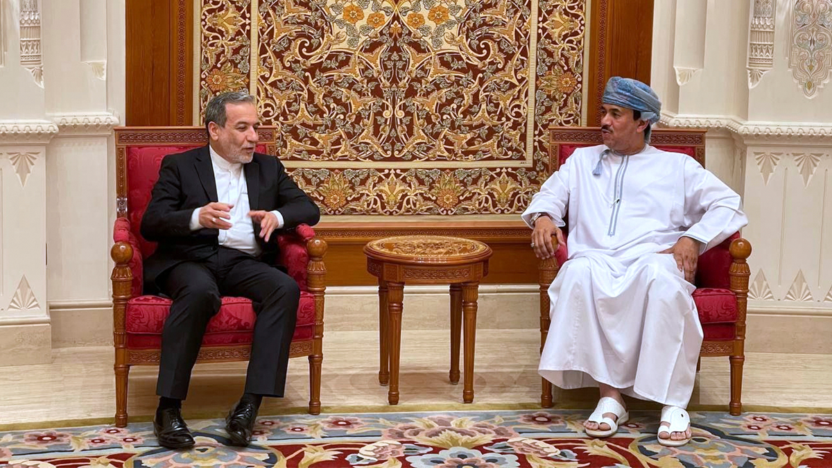 Iranian Foreign Minister Abbas Araghchi speaks with an Omani official