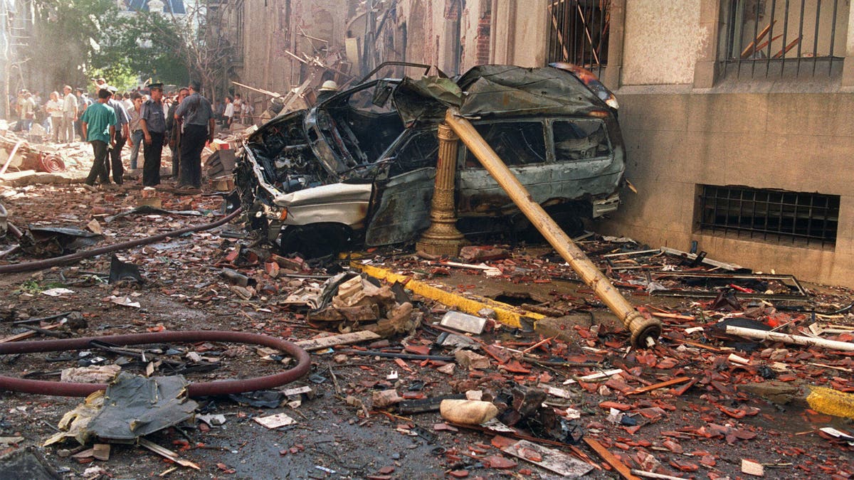 Police and rescue workers stand near destroyed cars and debris on March 17, 1992, in Buenos Aires shortly after a powerful bomb ripped through the Israeli Embassy, virtually destroying the five-story building and killing 29 people.