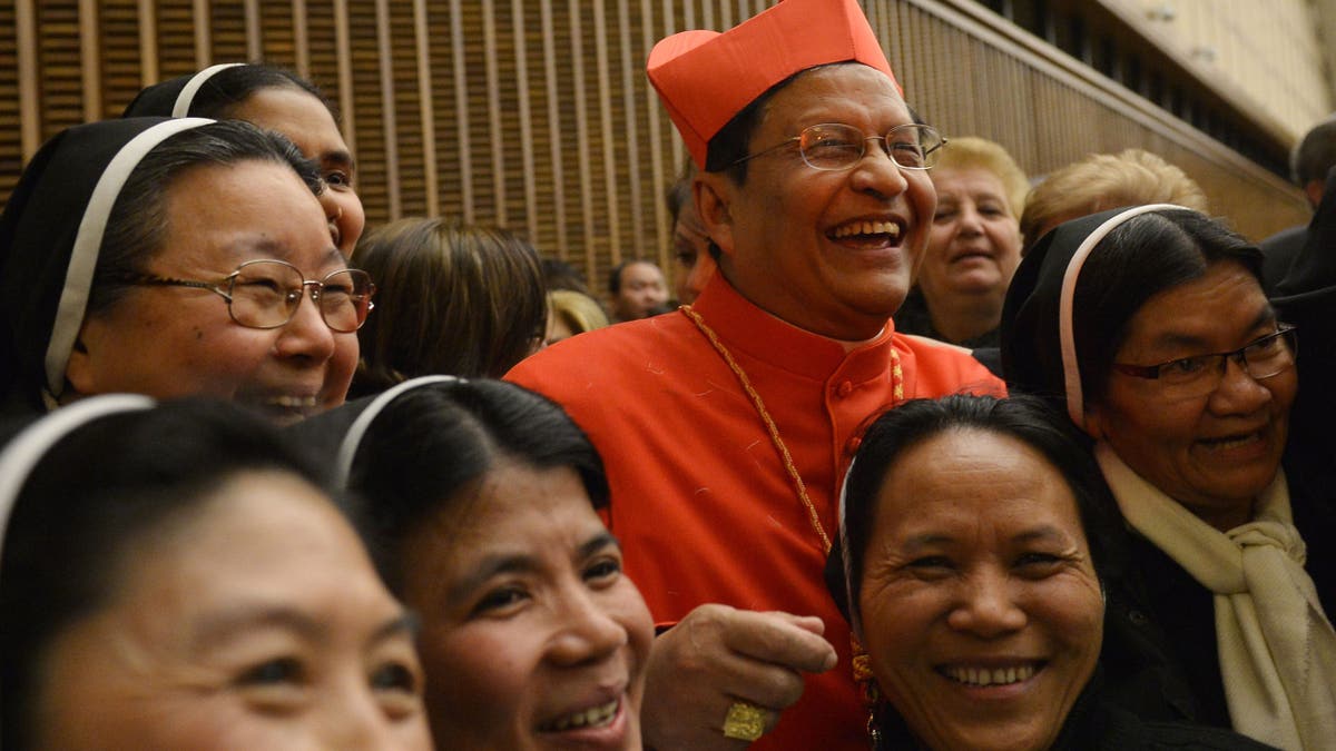 Cardinal Charles Maung Bo poses with people