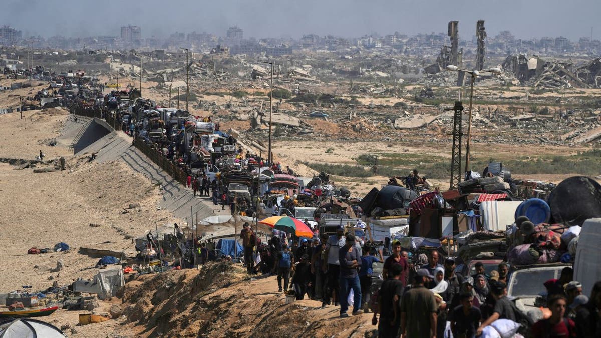 Palestinians evacuating Gaza City with belongings on vehicles.