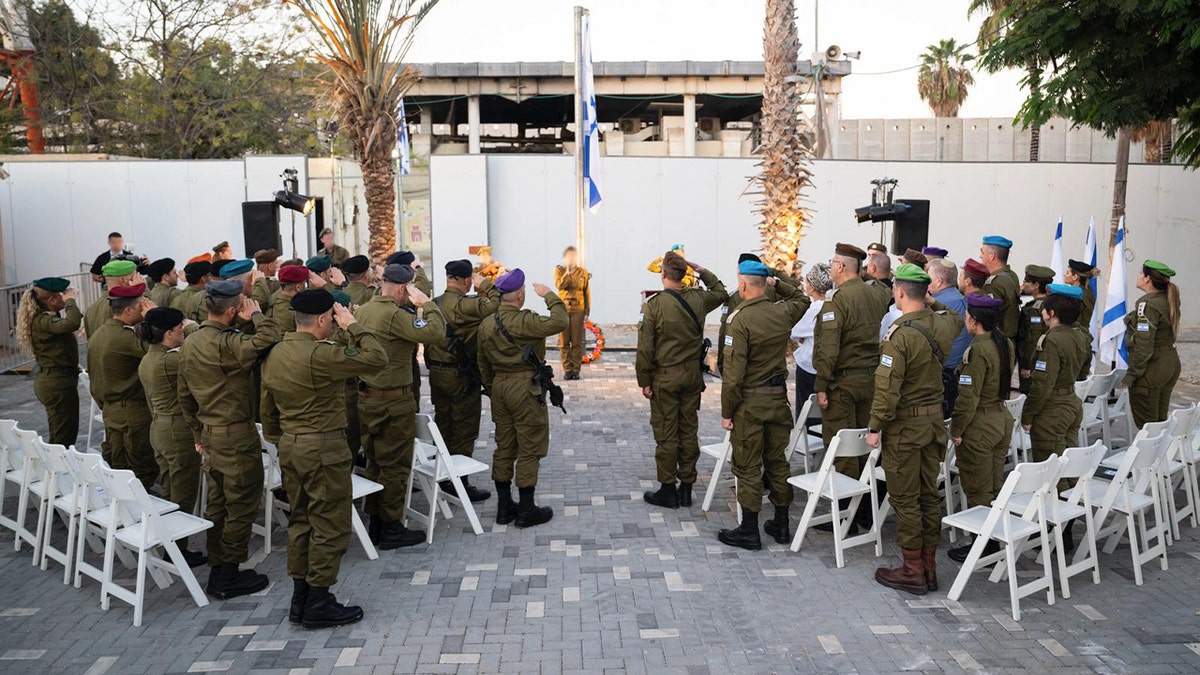 Israeli soldiers saluting during memorial.