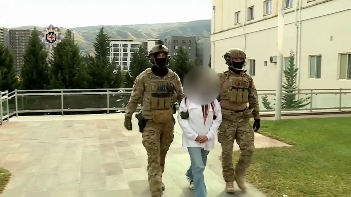 two officials escort suspect