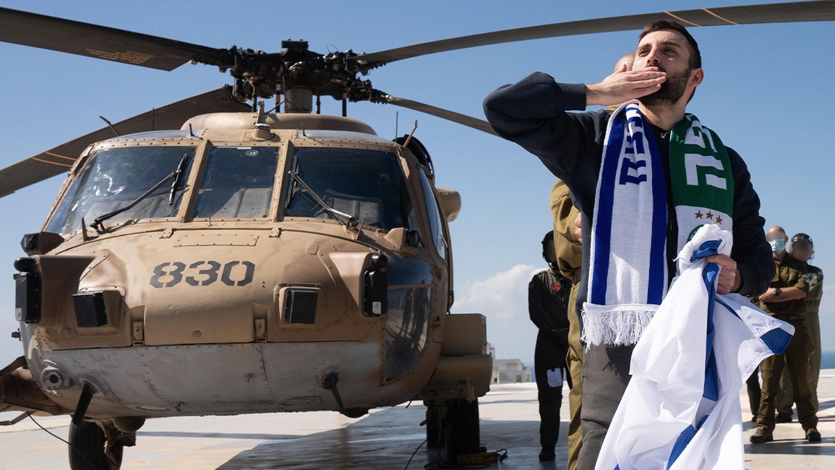 Matan Angrest seen in front of a helicopter