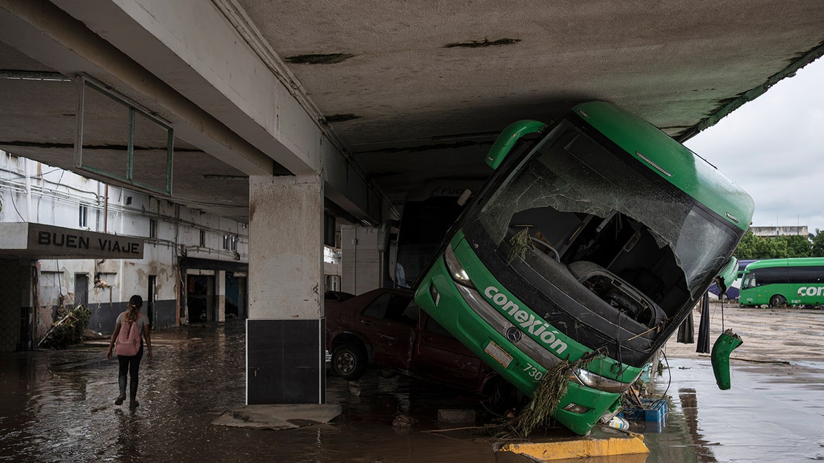 A car is washed under a bus at a bus station