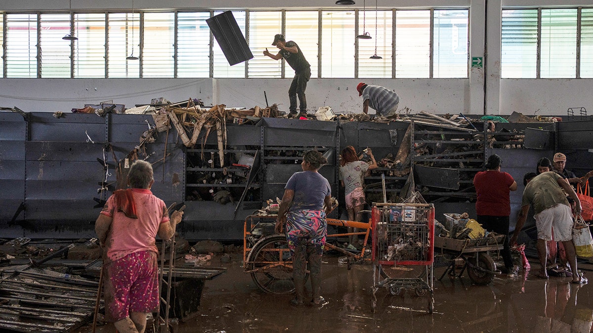 People looting items from the shelves of a supermarket