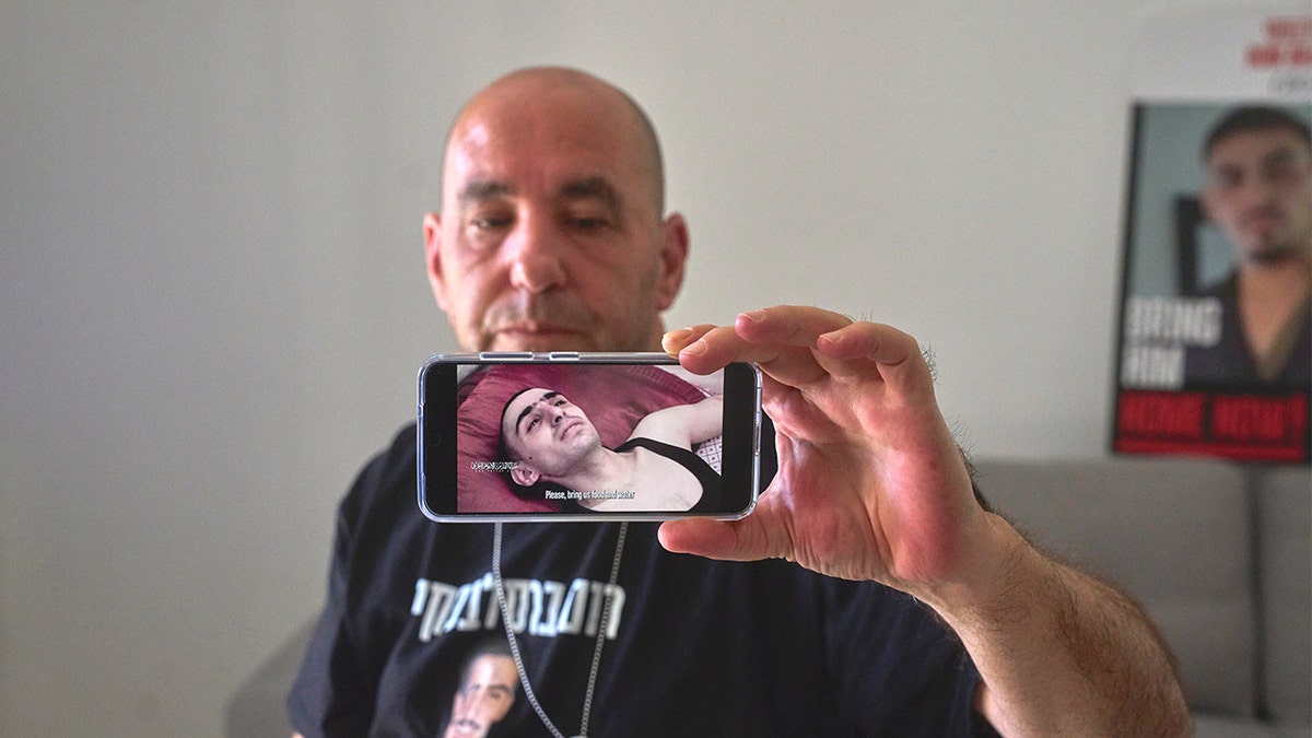 Ofir Braslavski shows an image from a video of his son, Rom, who is a hostage in Gaza