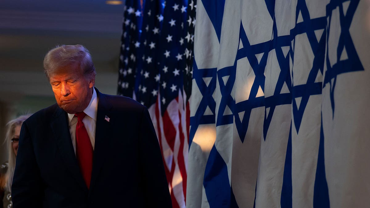 Trump stands in front on Israeli flags