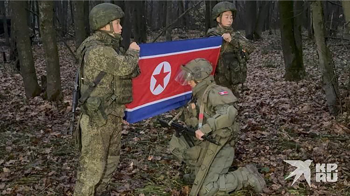 North Korean soldiers pose with their country's flag