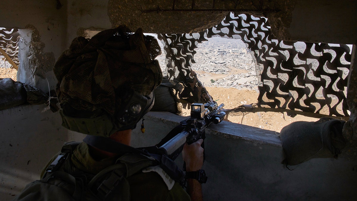 Israeli soldier aims weapon in Gaza