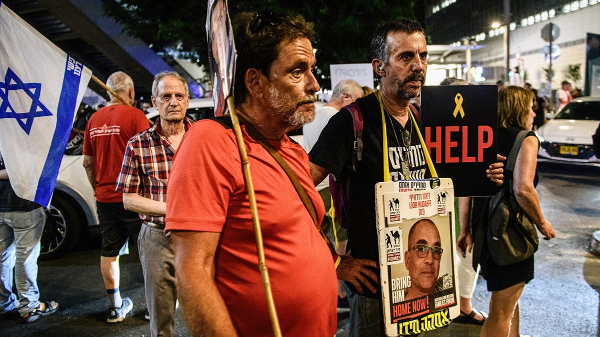 Protesters stand with sign of Israeli hostage Lior Rudaeff