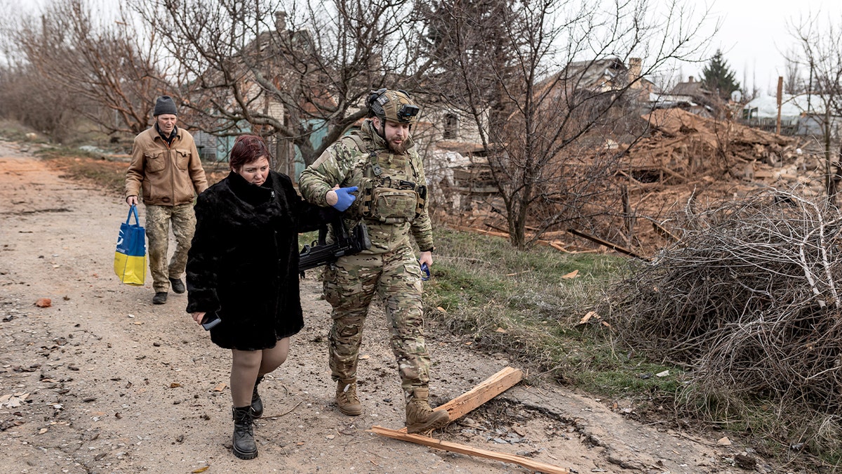Emergency medics provide medical care to an injured woman.