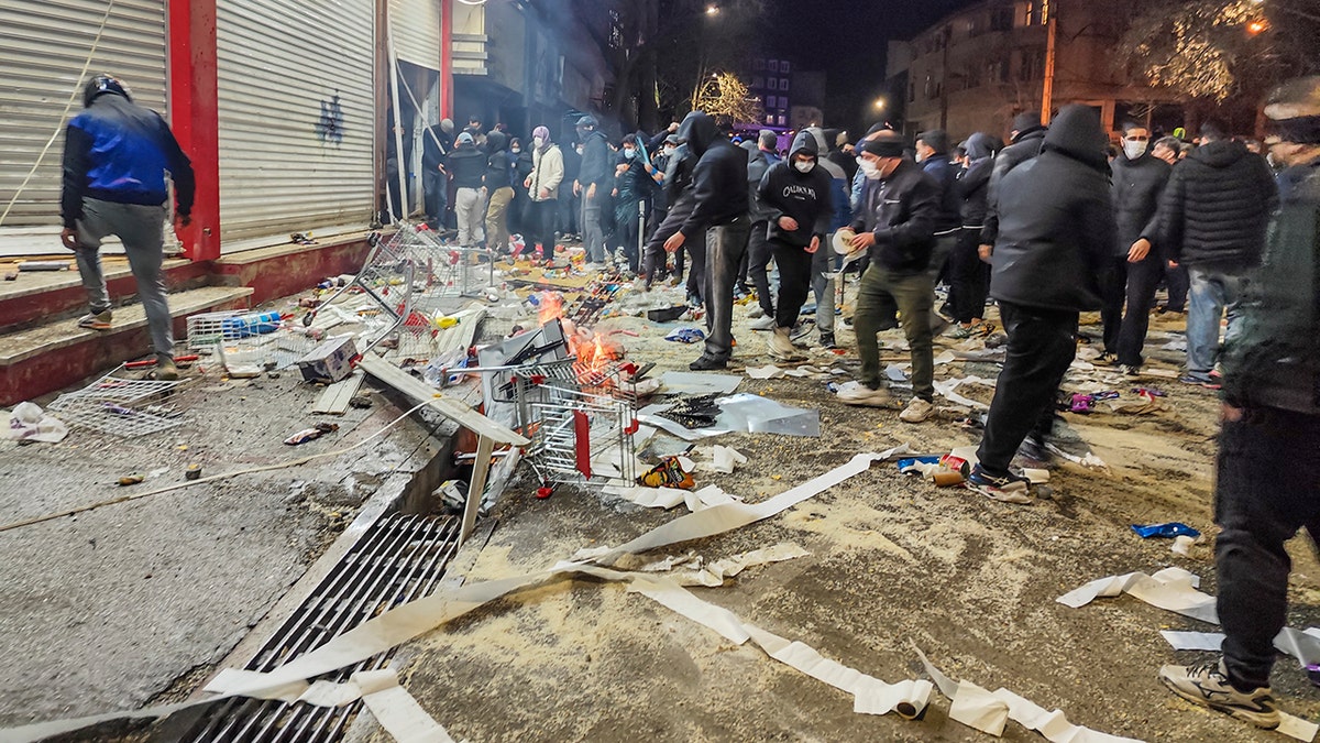 Iranians block street, stand among debris in Kermanshah, Iran