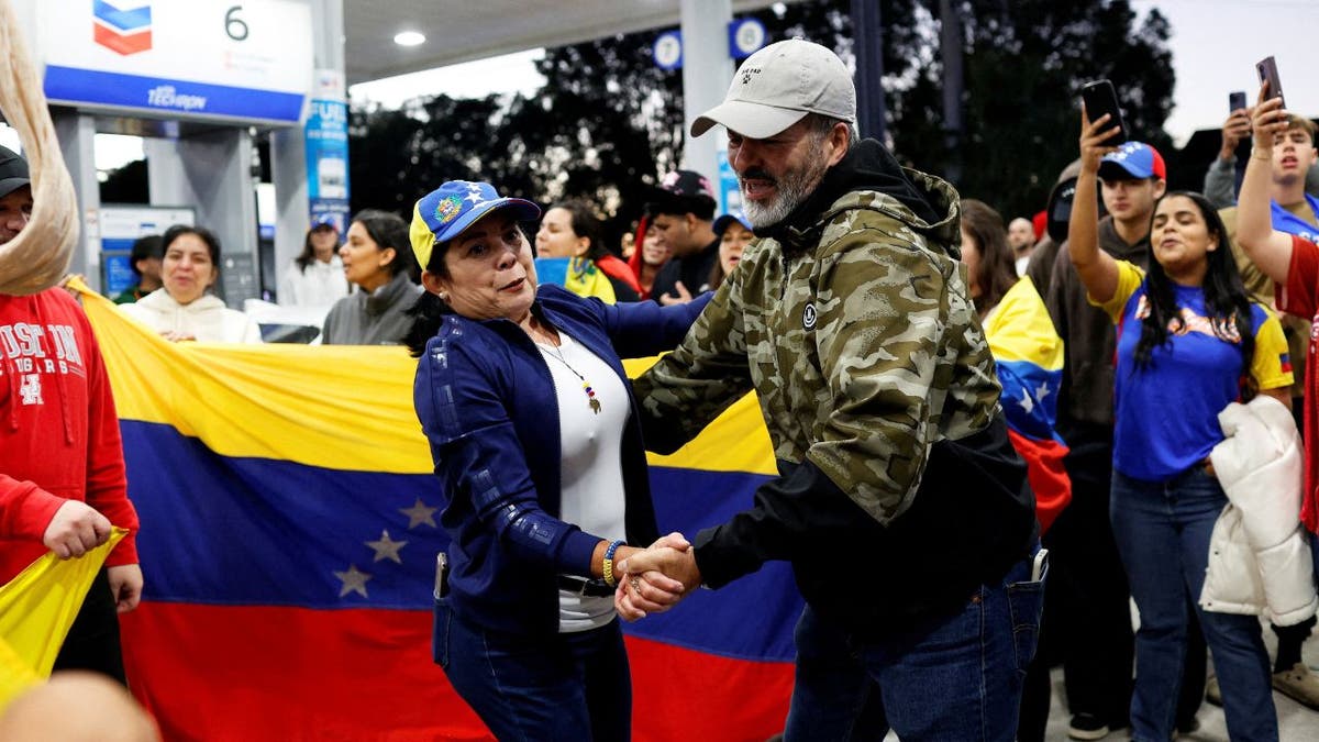 People in Miami holding Venezuelan flags react to news of President Nicolás Maduro’s capture.