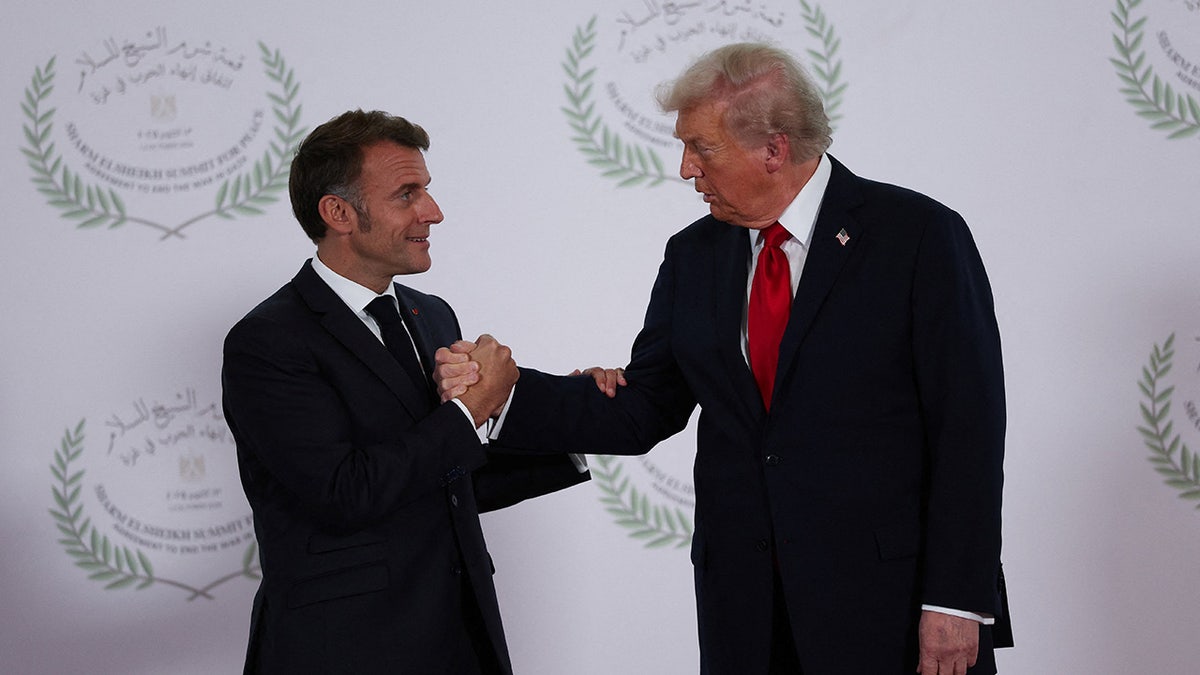 U.S. President Donald Trump and French President Emmanuel Macron shake hands as they pose for a photo, at a world leaders' summit on ending the Gaza war.