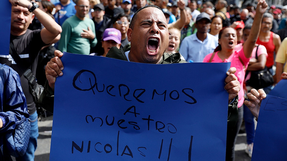 A man screaming with a sign
