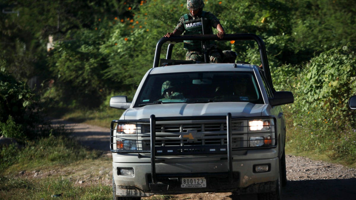 Mexican navy marines guard the area where new clandestine mass graves were found near the town of La Joya, on the ouskisrts of Iguala, Mexico, Thursday Oct. 9, 2014. Two weeks after 43 students disappeared in a confrontation with police in rural southern Mexico, Attorney General Jesus Murillo Karam announced that suspects had led investigators to four new mass graves near the southern city of Iguala where authorities unearthed 28 badly burned bodies last weekend. (AP Photo/Felix Marquez)