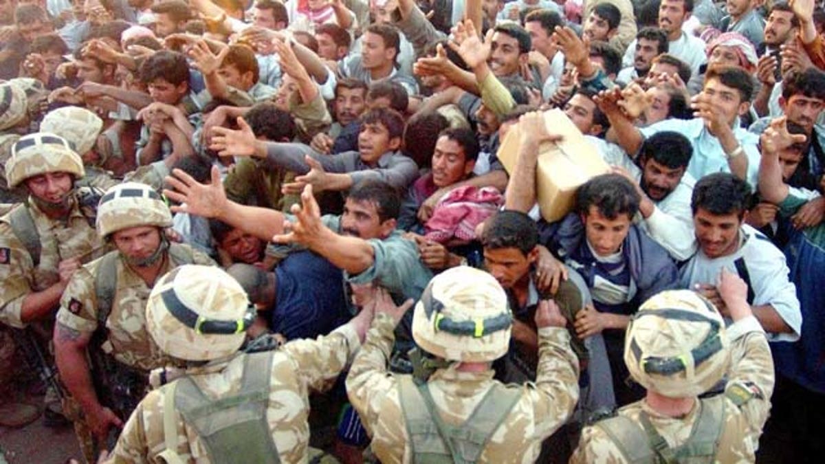 Soldiers of the British Light Infantry distribute aid packages to locals at Zubayr near Basra, southern Iraq, Saturday, March 29, 2003. Significant numbers of Iraqi civilians are trying to leave Basra everyday to get food aid from points around the city before returning.
