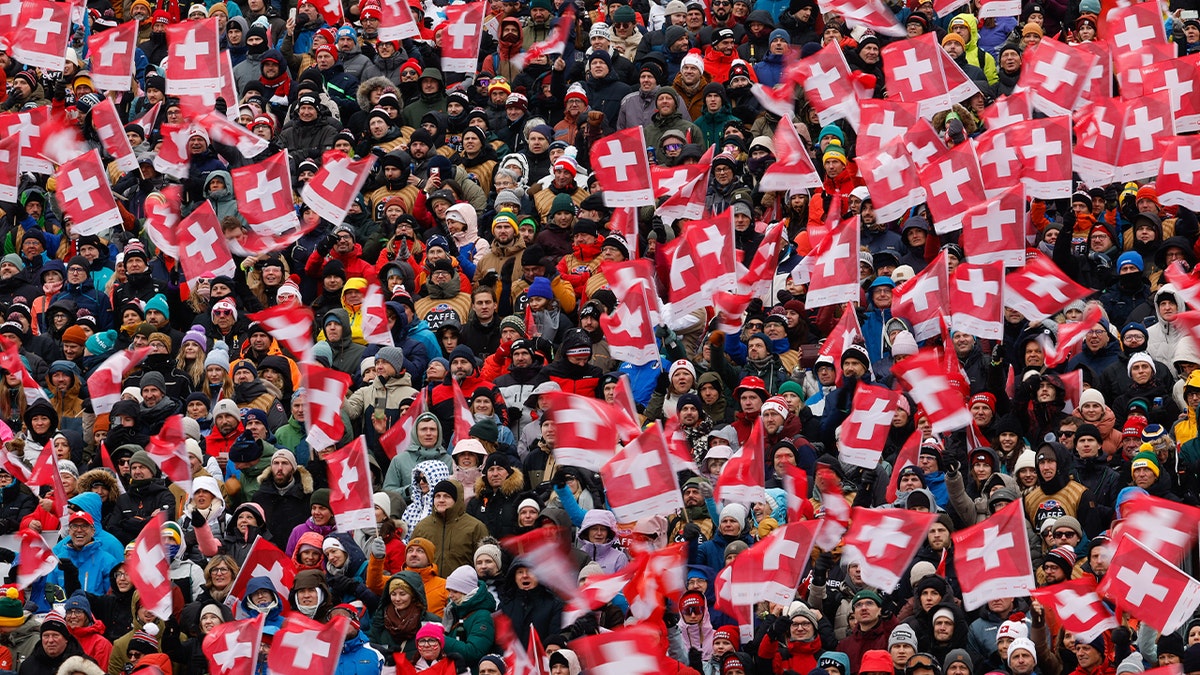 crowd holding swiss flags