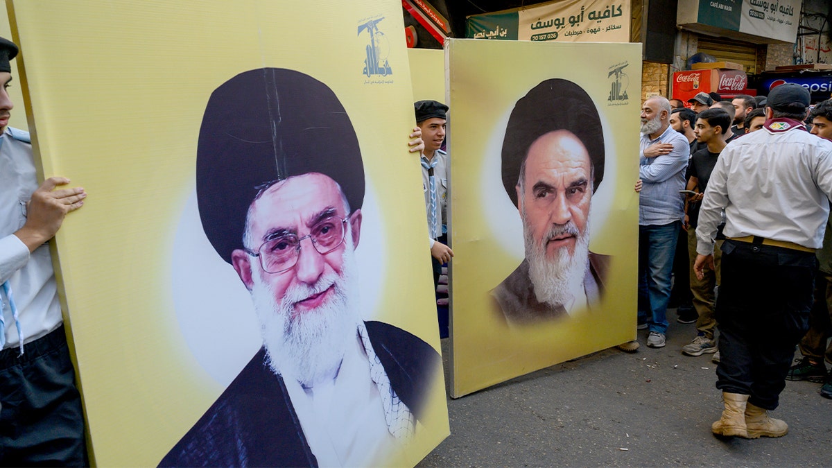 People carry large portraits of Ayatollah Ruhollah Khomeini and Ayatollah Ali Khamenei during a Hezbollah funeral procession in Beirut.