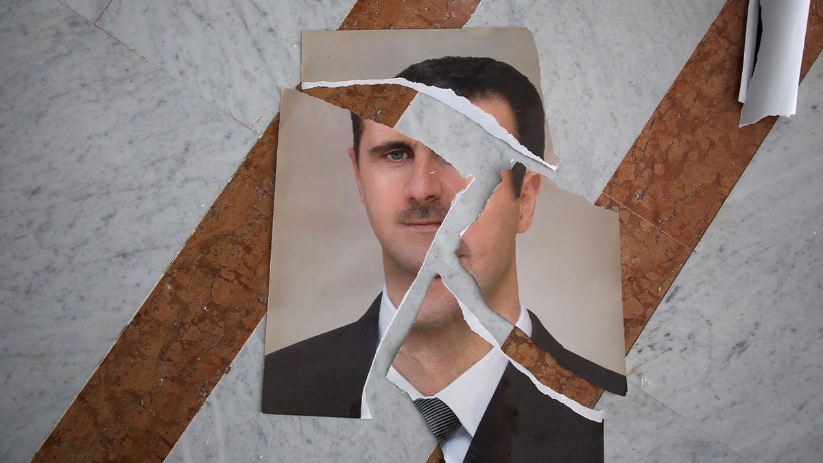 A ripped portrait of Syrian President Bashar al-Assad.