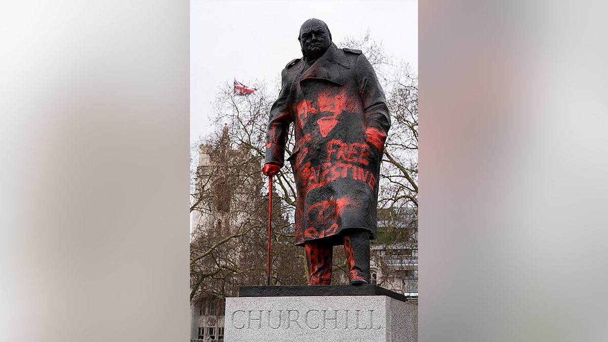 A statue of Winston Churchill covered in graffiti