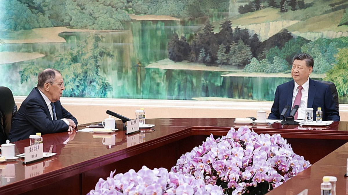 Russian foreign minister Sergey Lavrov and Chinese President Xi Jinping sit perpendicular to each other at a long wooden table