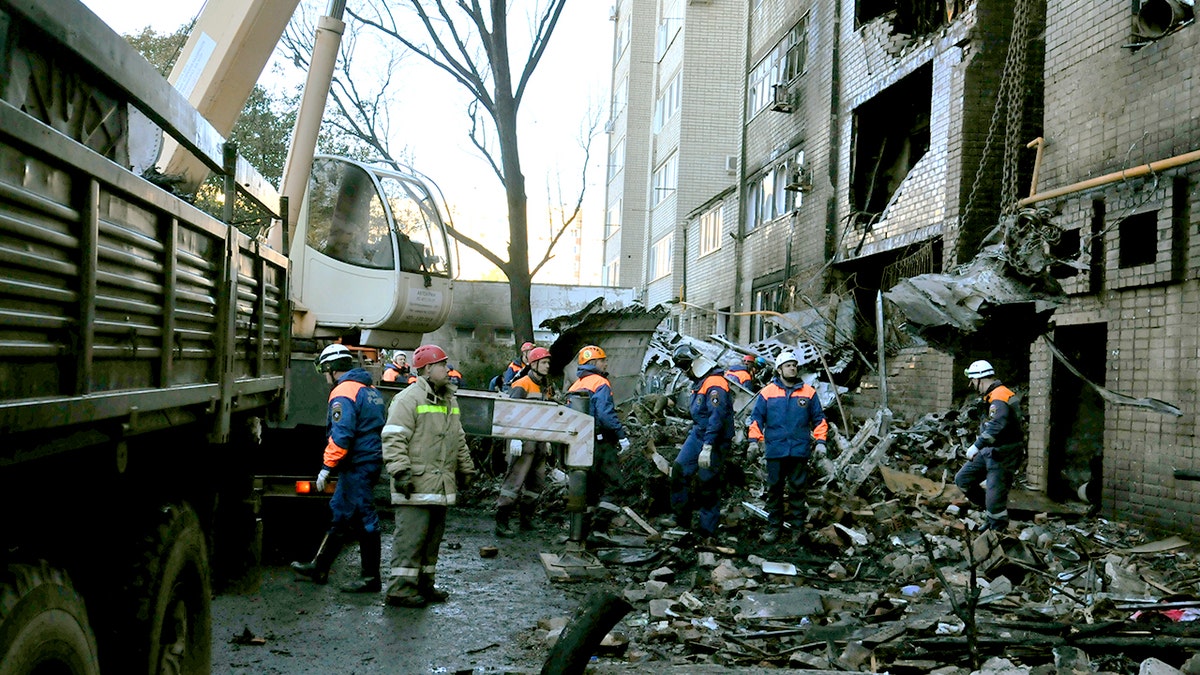 Russian officials inspect the site of a plane crash.