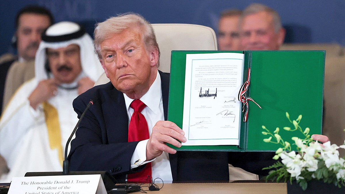 U.S. President Donald Trump holding a signed agreement at a summit in Sharm El-Sheikh Egypt