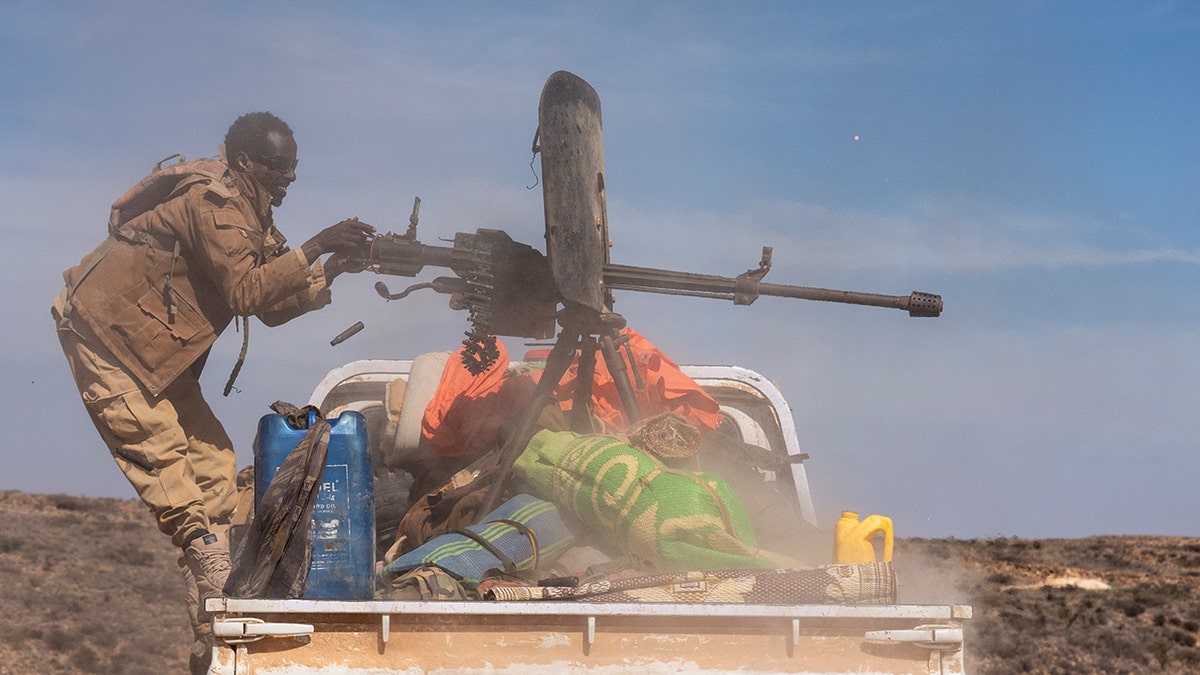 A Puntland Defense Force soldier firing a machine gun on a frontline near Daabdamale, Somalia