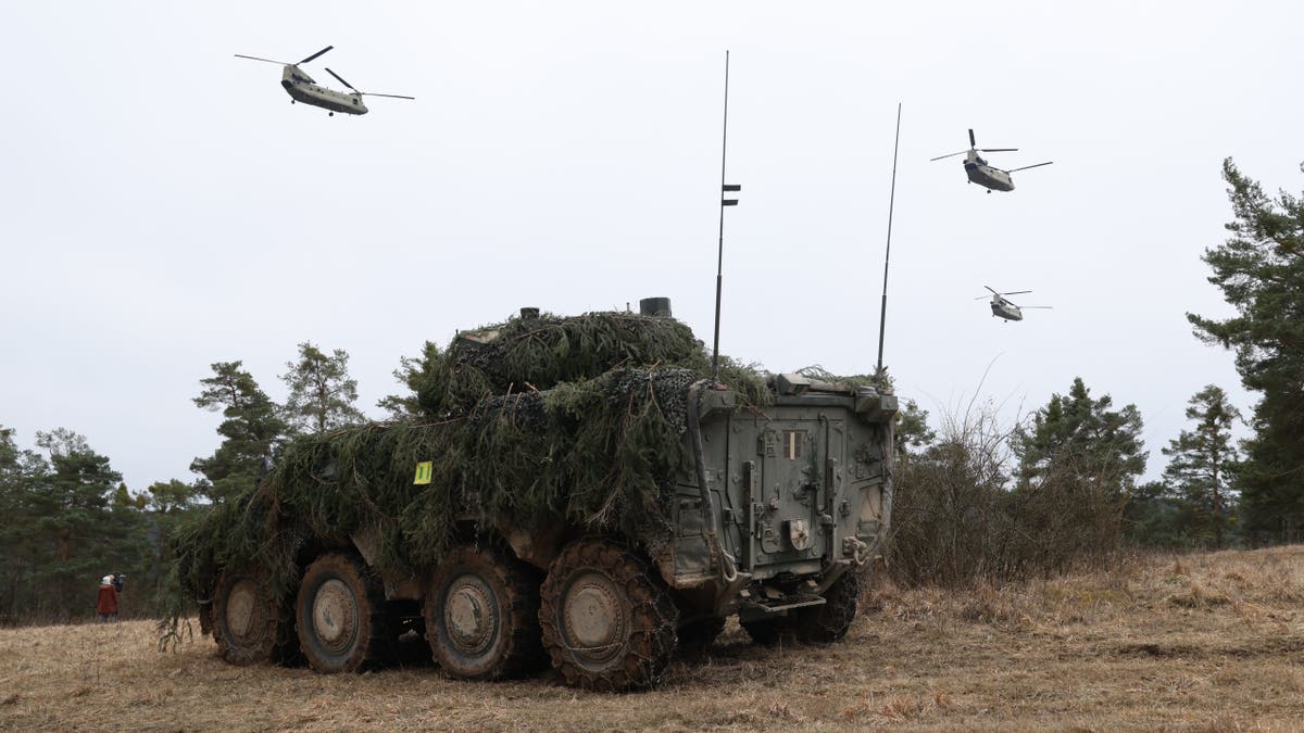 Boeing CH-47 Chinook helicopters flying over Lithuanian Vilkas infantry fighting vehicle near Hohenfels Germany