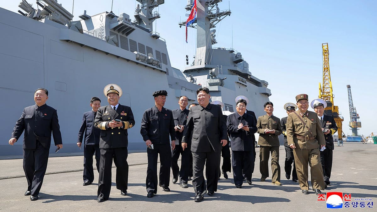 Kim Jong Un walks alongside officials in North Korea