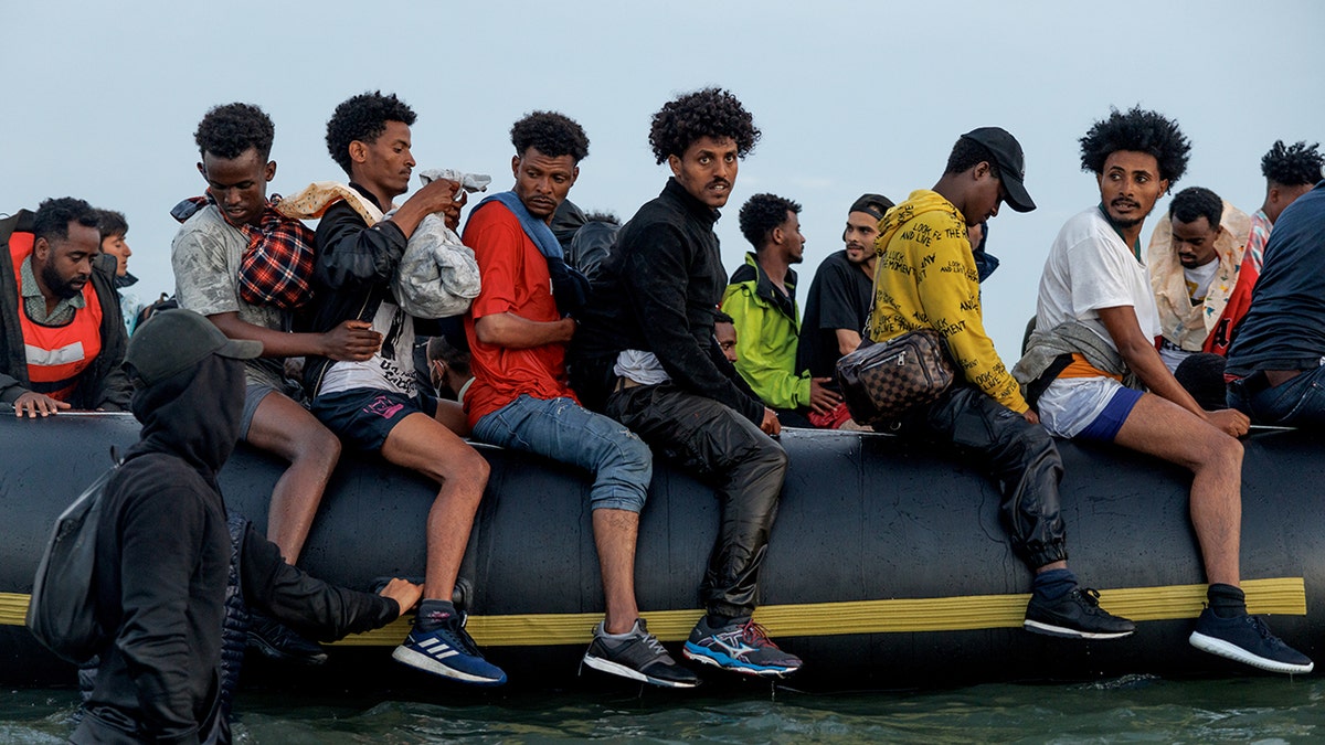 A small boat carrying migrants heads into the English Channel at sunrise near Gravelines, France