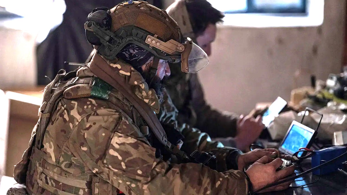 Service members of the strike UAV platoon controlling an FPV drone with optical fibre guidance in Kostiantynivka