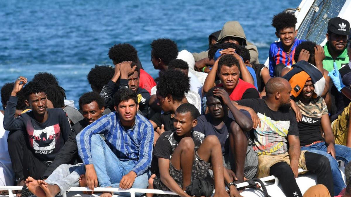 Migrants from Tunisia and Libya arriving on an Italian Coast Guard boat at Lampedusa