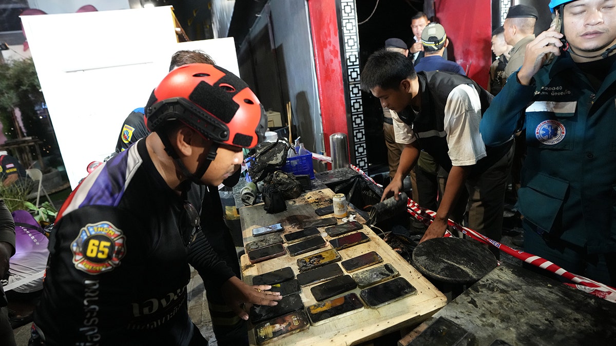 Mobile phones of victims of a fire are recovered in Bangkok