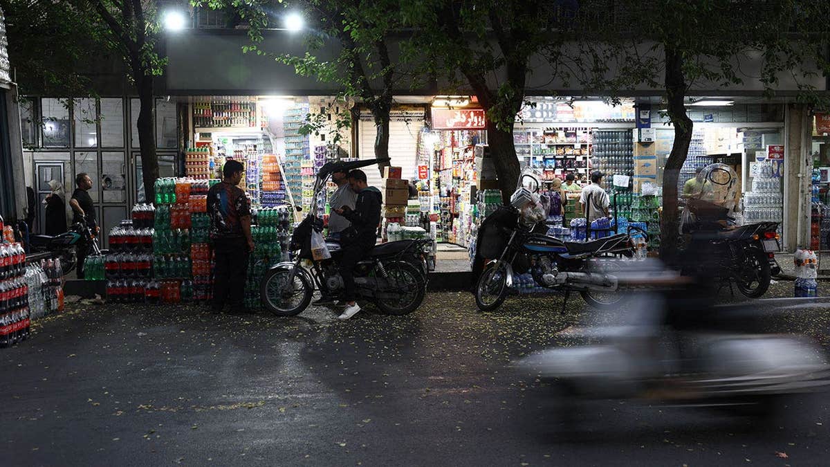 People shop in a local market in Tehran, Iran