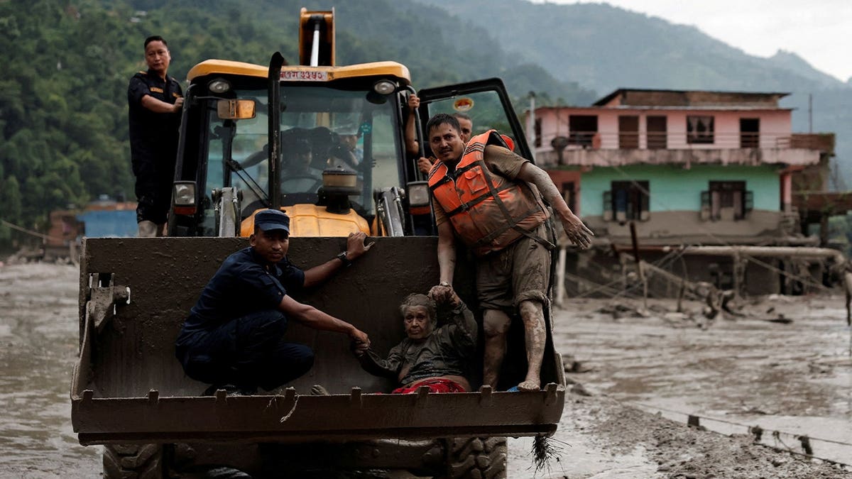 A survivor is transported to a safer place in a JCB following a flash flood at Trishuli in Nuwakot district, Nepal, August 26, 2026.