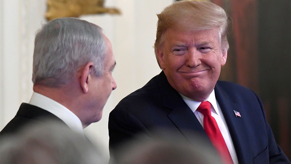 President Donald Trump, right, looks over to Israeli Prime Minister Benjamin Netanyahu, left, during an event in the East Room of the White House in Washington, Tuesday, Jan. 28, 2020, to announce the Trump administration's much-anticipated plan to resolve the Israeli-Palestinian conflict. (AP Photo/Susan Walsh)