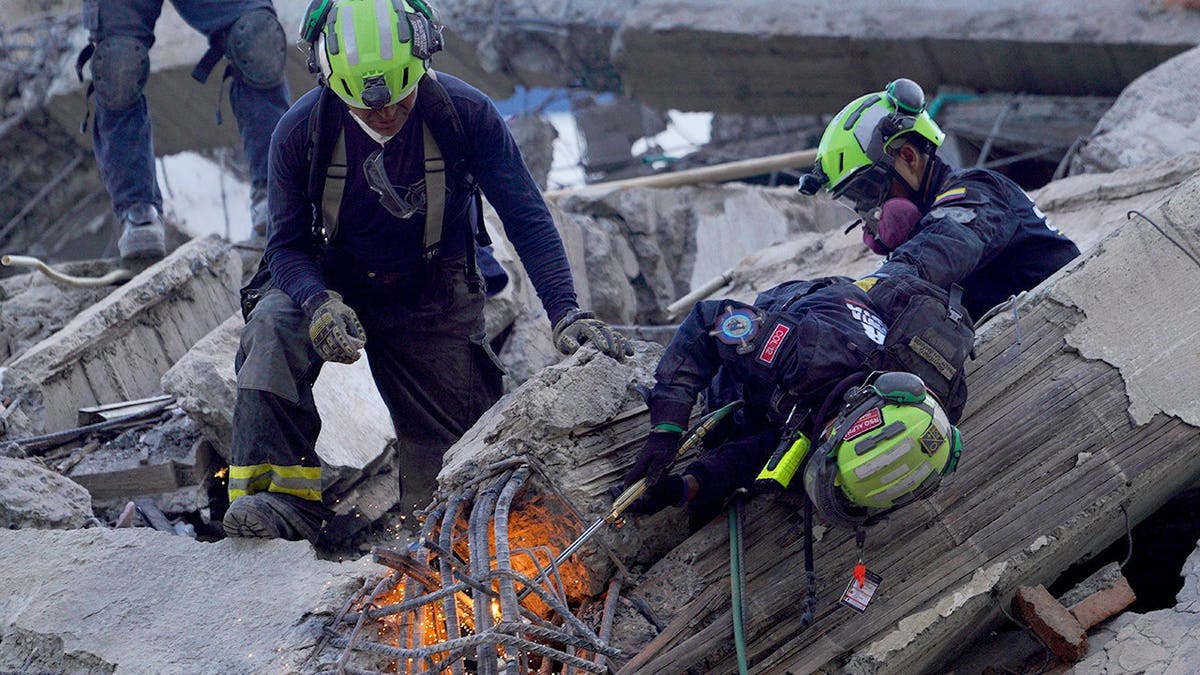 Rescue workers cut through debris searching for survivors in Cali, Colombia.